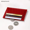 A red crocodile pattern slim card holder wallet displaying various coins.