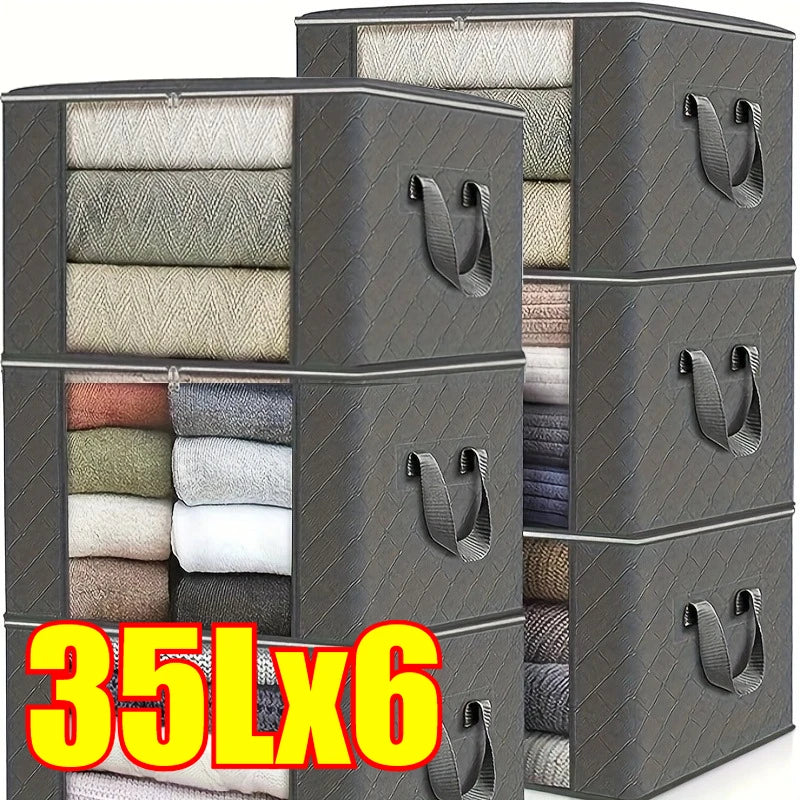 A stack of dark gray foldable storage bags filled with various textiles and clothing items.