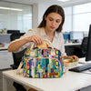 A multi-color oxford cloth picnic lunch bag resting on a white desk in an office setting.