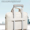 A beige trolley belt design laptop bag is shown resting on a gray suitcase.