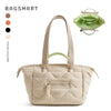 A beige quilted tote bag with a light green detachable strap is shown next to its folded green fabric pouch.