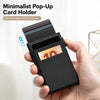 Une main tient un porte-cartes pop-up noir et minimaliste affichant plusieurs cartes de crédit.