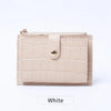 A light beige mini card holder made of crocodile pattern leather with a zipper closure.