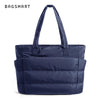 Sac fourre-tout matelassé bleu marine avec poignée, vu de face.