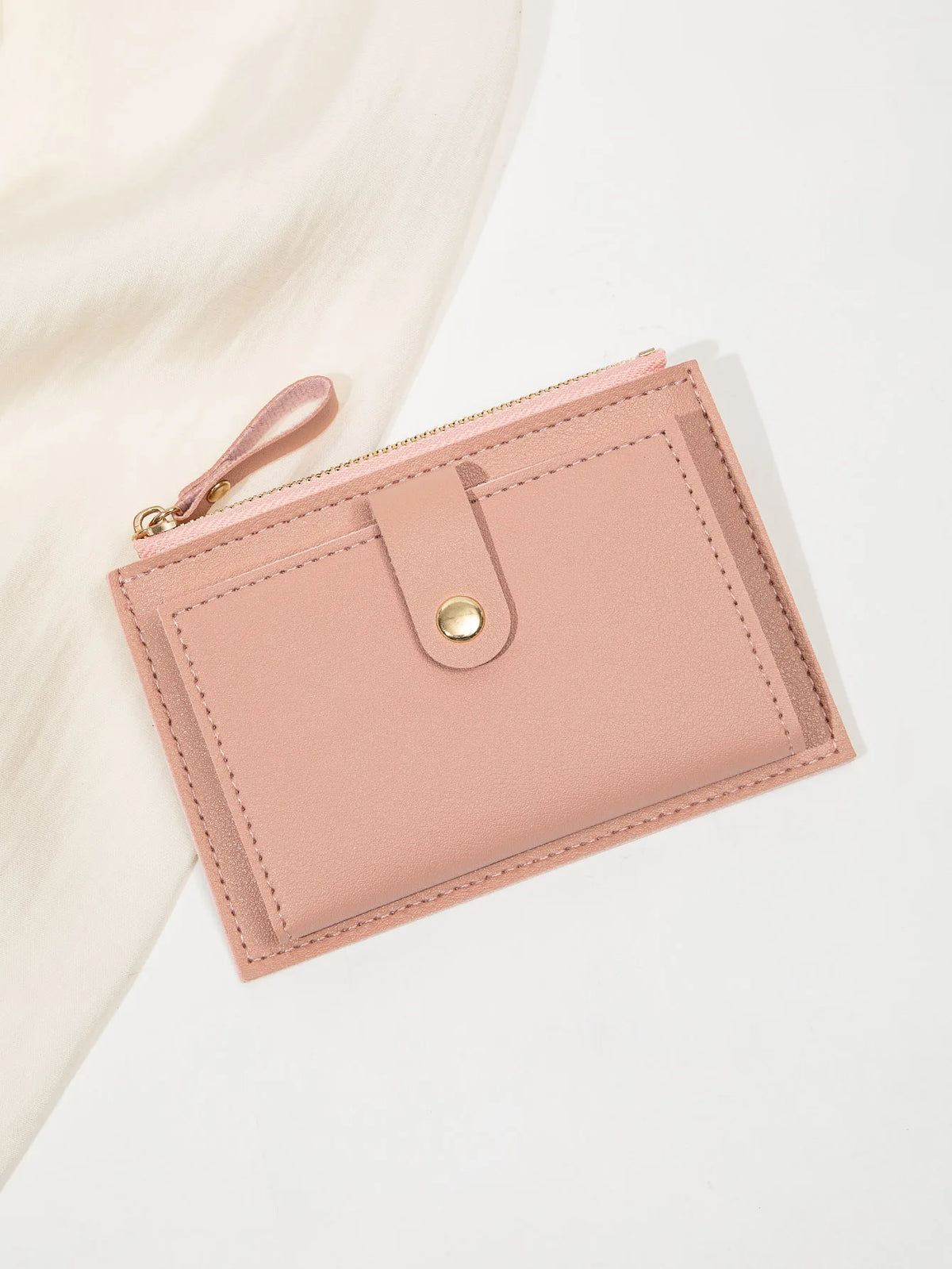 A light pink ultra-thin PU leather card holder wallet with a stitched flap and leather pull tab.
