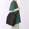 Una persona con una camisa verde lleva un soporte y caja de almacenamiento para sombrero resistente al exterior negro.