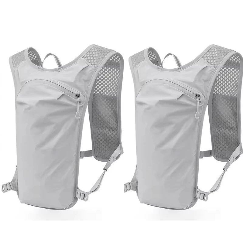A pair of light gray running and cycling hydration vest backpacks shown side by side.