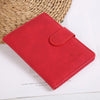 Portefeuille passeport en cuir rouge posé sur une surface blanche à côté d'un panier tissé.
