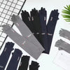Collection de manches de protection UV en soie glacée noir et gris étalées sur une surface blanche.