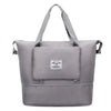 A gray expandable travel organizer bag with shoulder straps shown from the front.