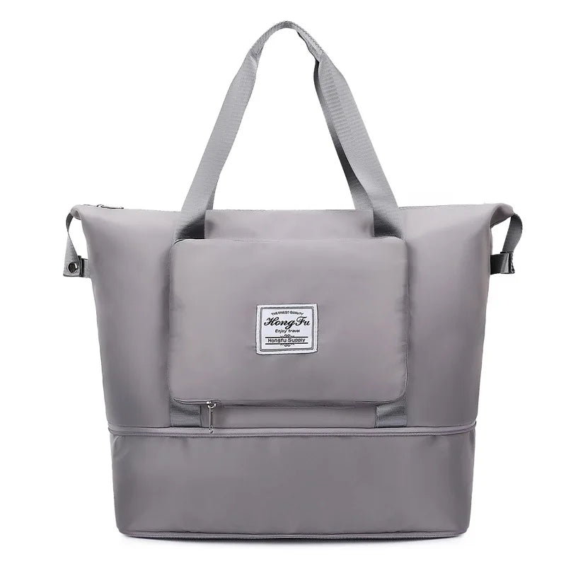 A gray expandable travel organizer bag with shoulder straps shown from the front.