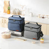 A blue insulated thermal lunch bag sits on a white countertop next to various kitchen items and food.