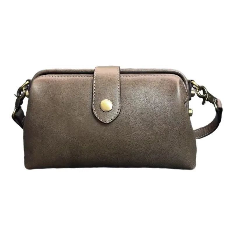 A brown genuine leather crossbody bag with a flap closure and gold-toned hardware.