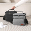 A hand is holding a gray insulated thermal lunch bag, showing its design and texture.