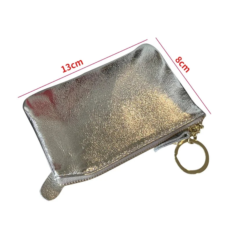 Silver metallic leather compact coin purse and key holder with a gold-colored ring.