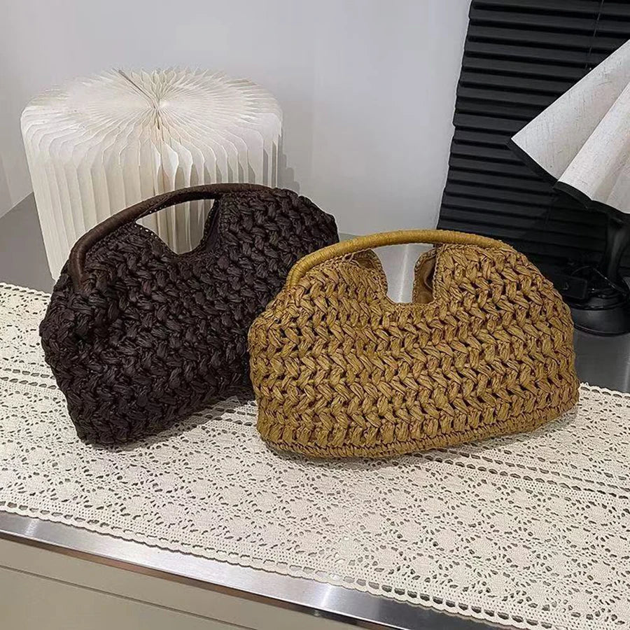 Un paire de pochettes en fibre naturelle à fermeture éclair, brun foncé et jaune doré, tissées, posées sur un tapis de dentel
