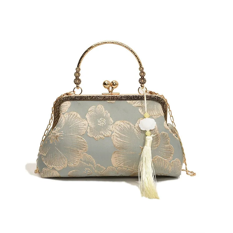 A light gray silk evening clutch with gold embroidery and a chain strap.