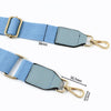 Light blue canvas cotton bag strap with metal hooks and a rectangular leather patch.