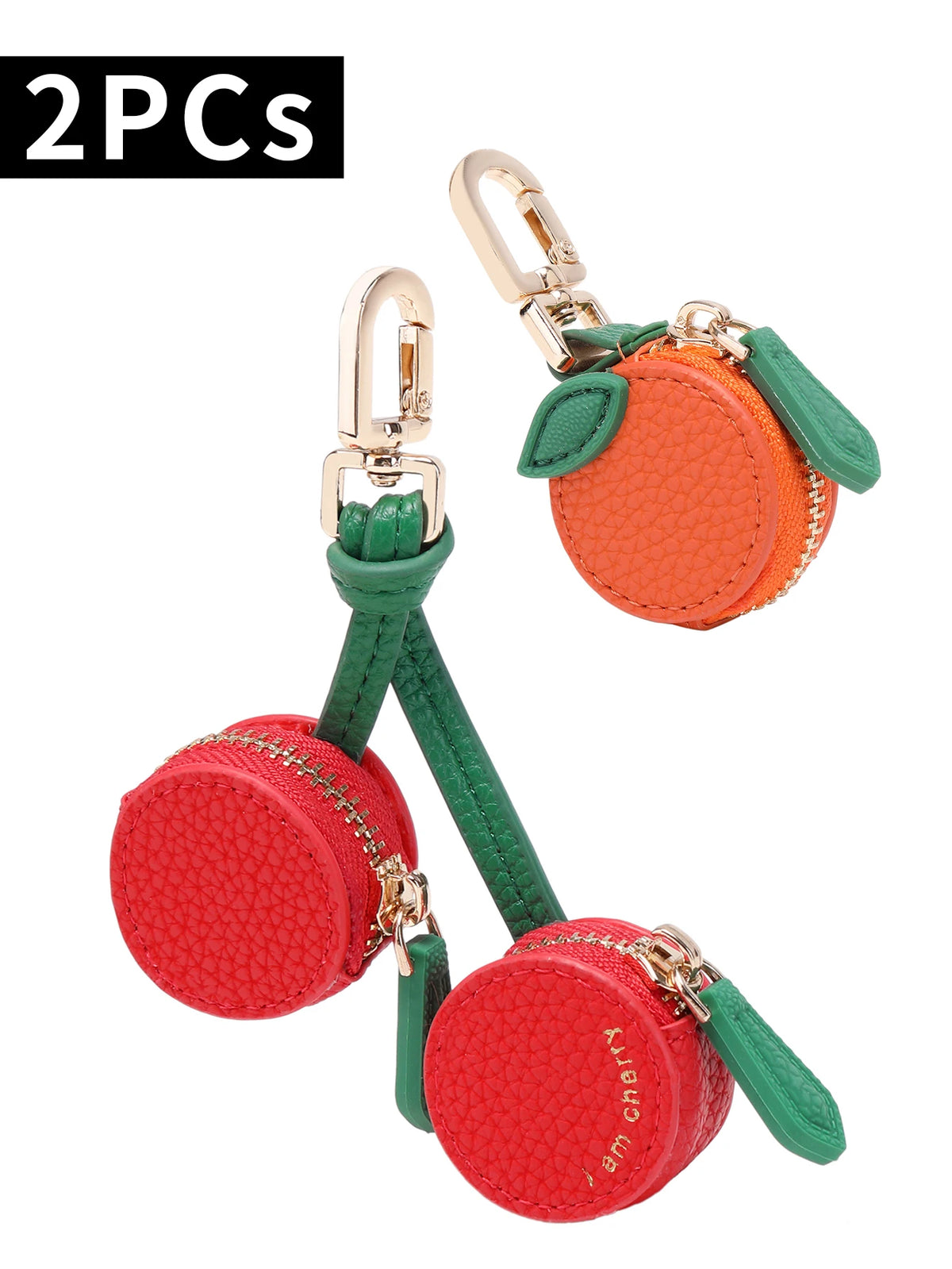 Two red cherry fruit shape coin purse keychains with gold hardware and green fabric.