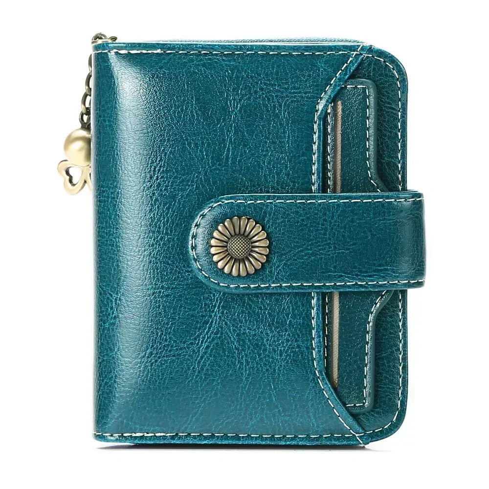 A teal leather wallet with a clasp closure and card slots shown in a close-up view.