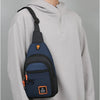 A man wearing a gray hoodie with a navy blue nylon chest bag slung over his shoulder.