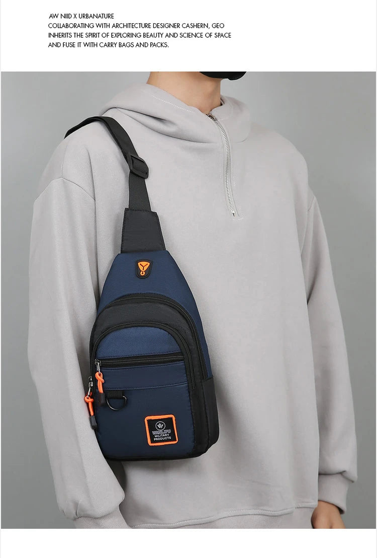 A man wearing a gray hoodie with a navy blue nylon chest bag slung over his shoulder.