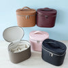 Three travel makeup organizers in beige, maroon, and pink colors displayed on a light blue background.