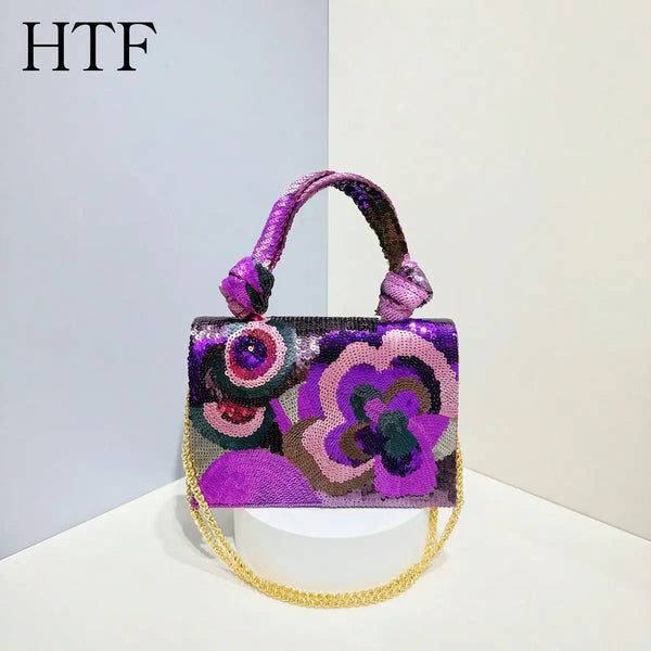 A purple and pink sequin embroidered floral clutch bag with a gold chain strap.