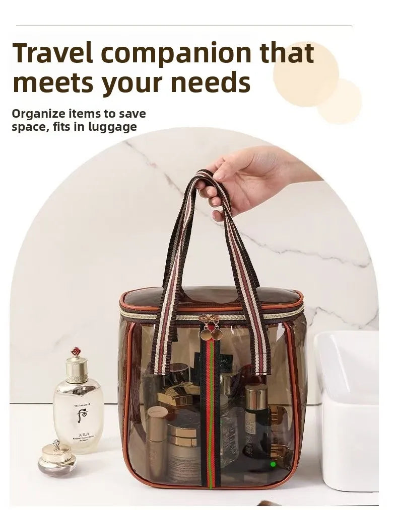 A clear waterproof travel toiletry bag with brown and black striped straps and various grooming products is shown on a white 
