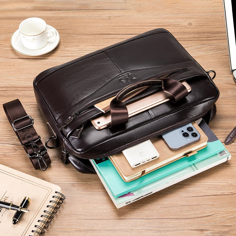 A brown genuine cowhide leather briefcase bag is shown open on a wooden surface with a smartphone and papers.
