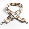 A beige and brown patterned jacquard strap for an adjustable wide crossbody bag.