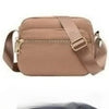 A tan leather crossbody bag with a flap closure and strap shown from the front.