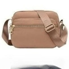 A tan leather crossbody bag with a flap closure and strap shown from the front.