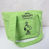 A lime green canvas shoulder bag featuring a Snoopy cartoon design.