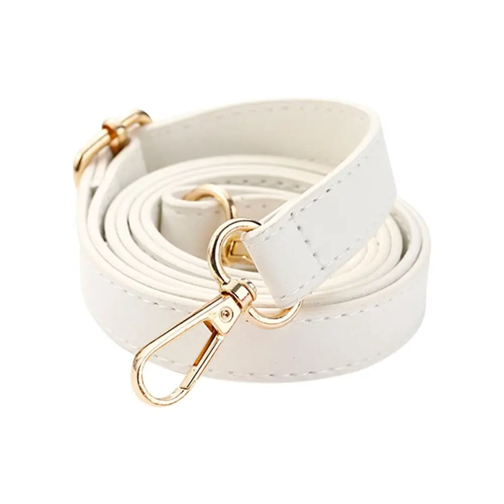 Un rouleau de sac à bandoulière en cuir blanc ajustable avec quincaillerie dorée.