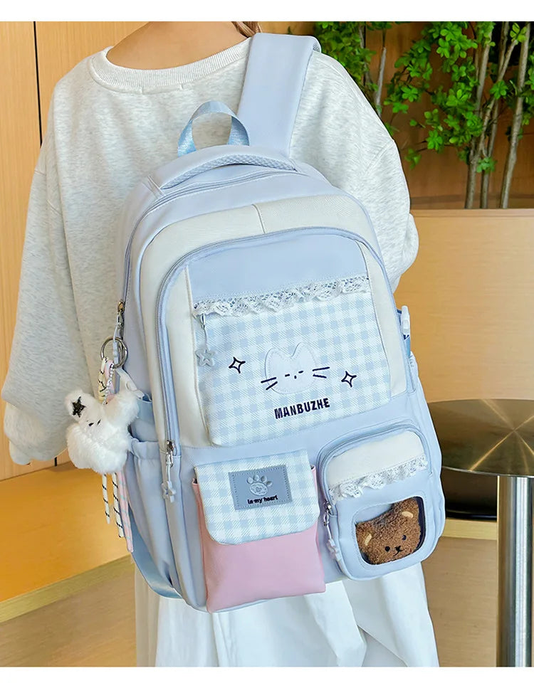 A light blue and white backpack featuring a laptop compartment and decorative lace details.