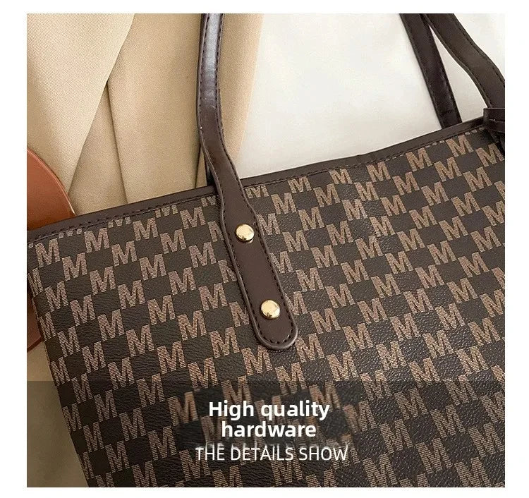 A close-up of a black faux leather tote bag featuring a gold hardware detail and a monogram print.