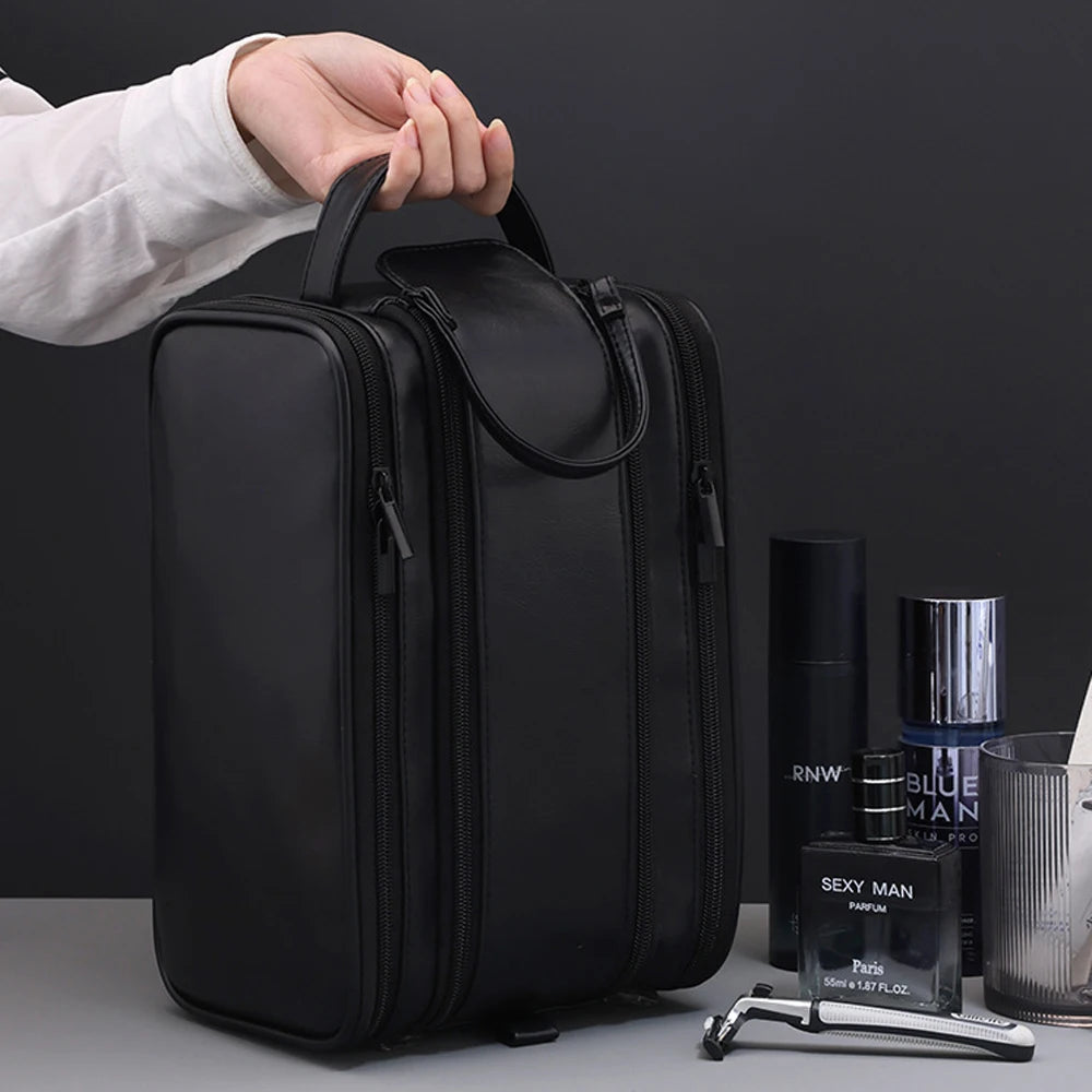 Une main tient un sac de toilette voyage en cuir PU noir haut de gamme pour hommes sur un fond sombre.