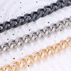 Three strands of heart-shaped metal purse chains in black, silver, and gold laid diagonally on a white background.
