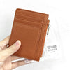 A brown genuine leather zipper card holder and coin purse is shown being held by a hand.
