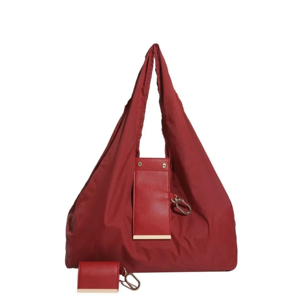 A maroon reusable nylon mini keychain tote bag with a leather strap and attached key ring.
