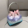 A purple and blue glittery fabric clutch with a pink drawstring and silver chain strap.