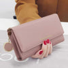 A light pink waterproof nylon crossbody bag with gold hardware is held by a hand.