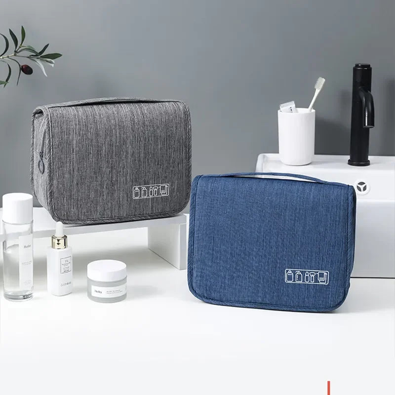 Un sac organisateur en tissu gris et un sac organisateur en denim bleu sont exposés sur une surface blanche.