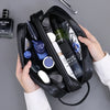 A black premium PU leather toiletry bag for men is shown open, containing various grooming products and a cologne bottle.