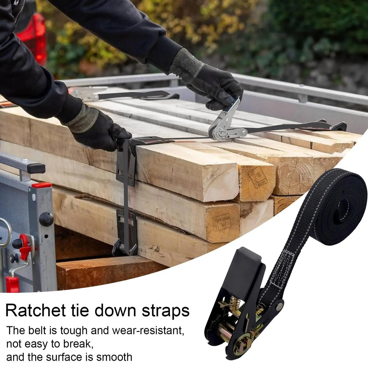 Close-up of heavy duty ratchet tie-down straps being used to secure wooden planks on a flatbed.