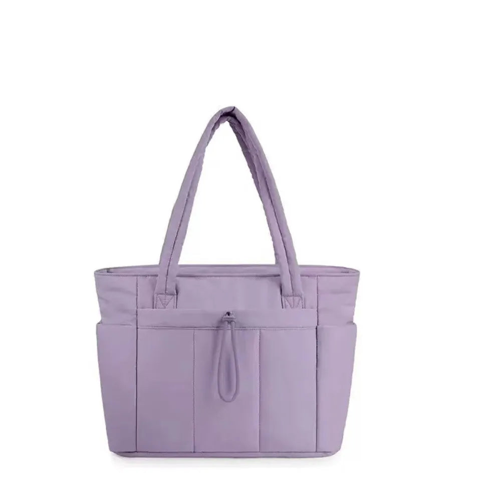 A lavender quilted padded tote bag with a handle and multiple pockets.