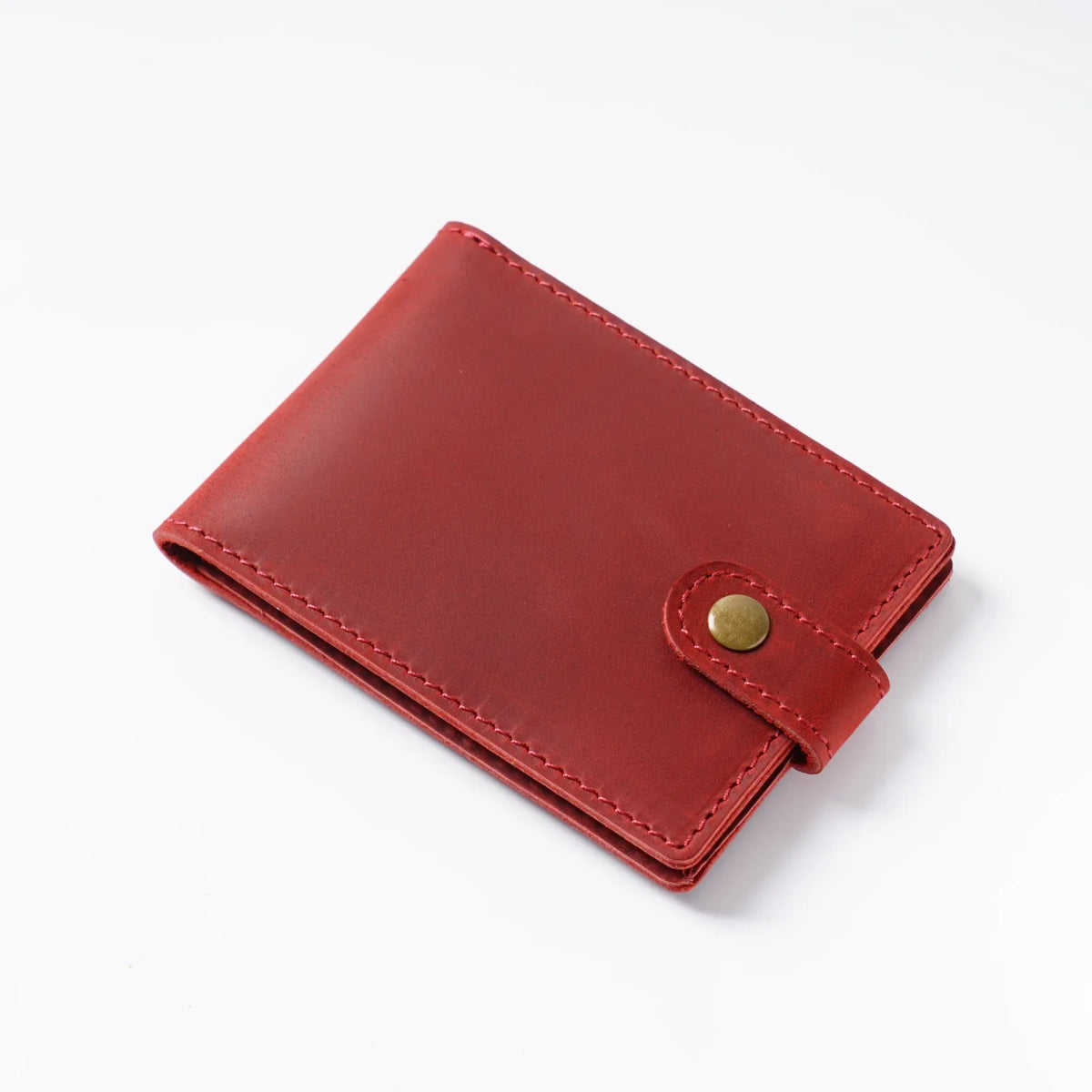 Portefeuille rouge en cuir véritable à rabat avec fermeture cousue.