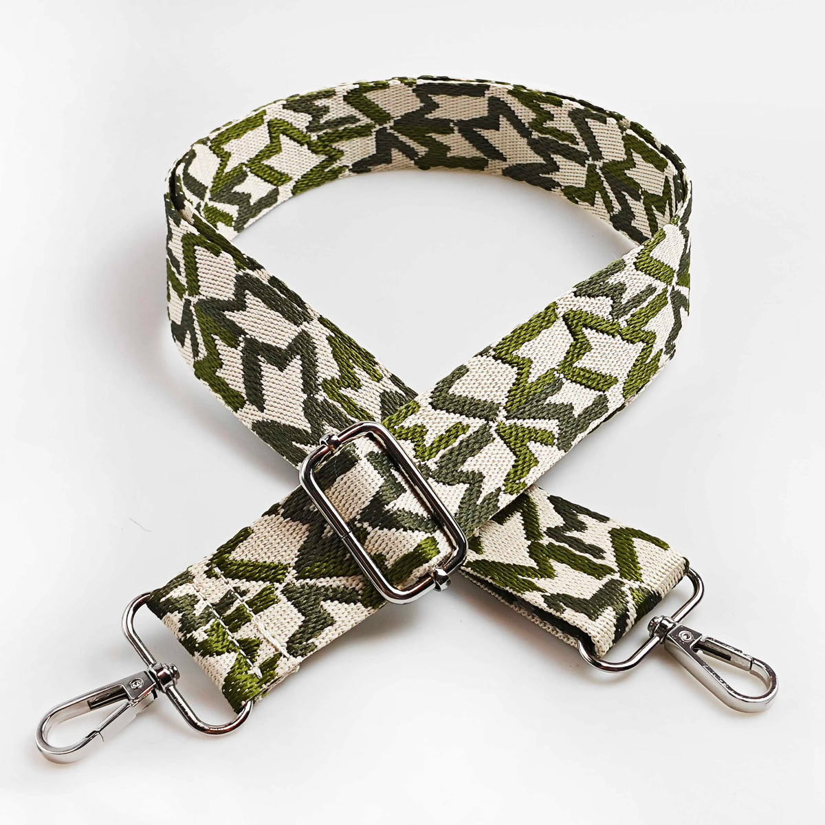 A beige and olive green jacquard patterned strap for an adjustable crossbody bag.