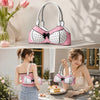 A pink and white polka dot bow shoulder bag with a playful bra silhouette displayed on a light surface.